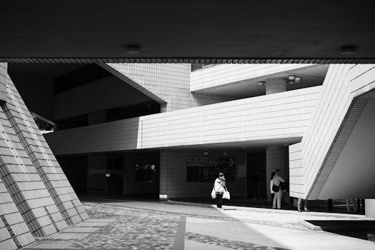 Black and white photograph showcasing a unique architectural structure in Kowloon, Hong Kong, with people in view.