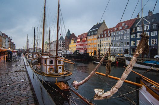 Vibrant Nyhavn harbor in Copenhagen with docked boats against colorful historic buildings.