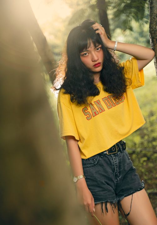 Free Fashionable woman in yellow top posing outdoors with bold style. Stock Photo