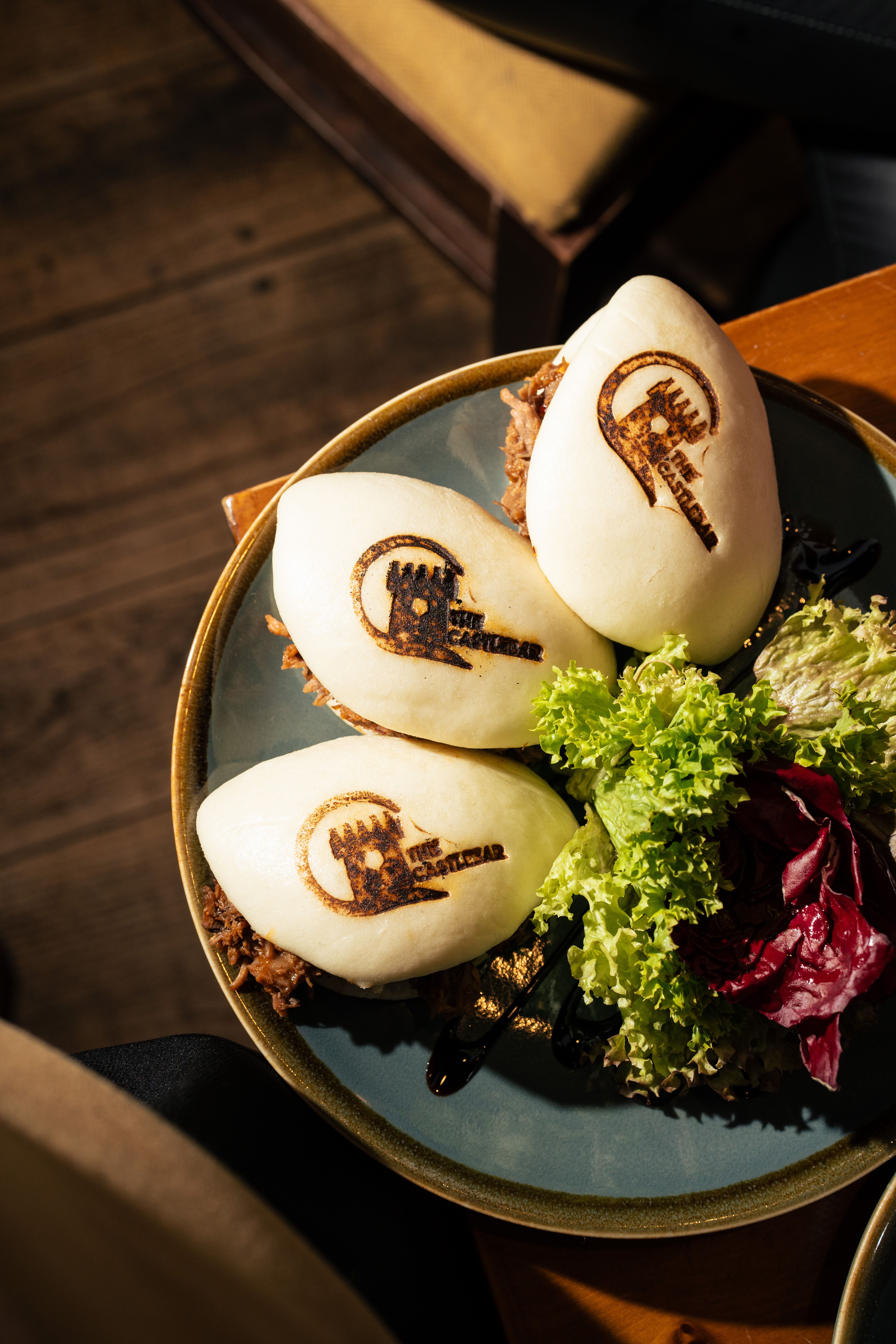 Delicious bao buns with unique brand markings served with fresh salad.