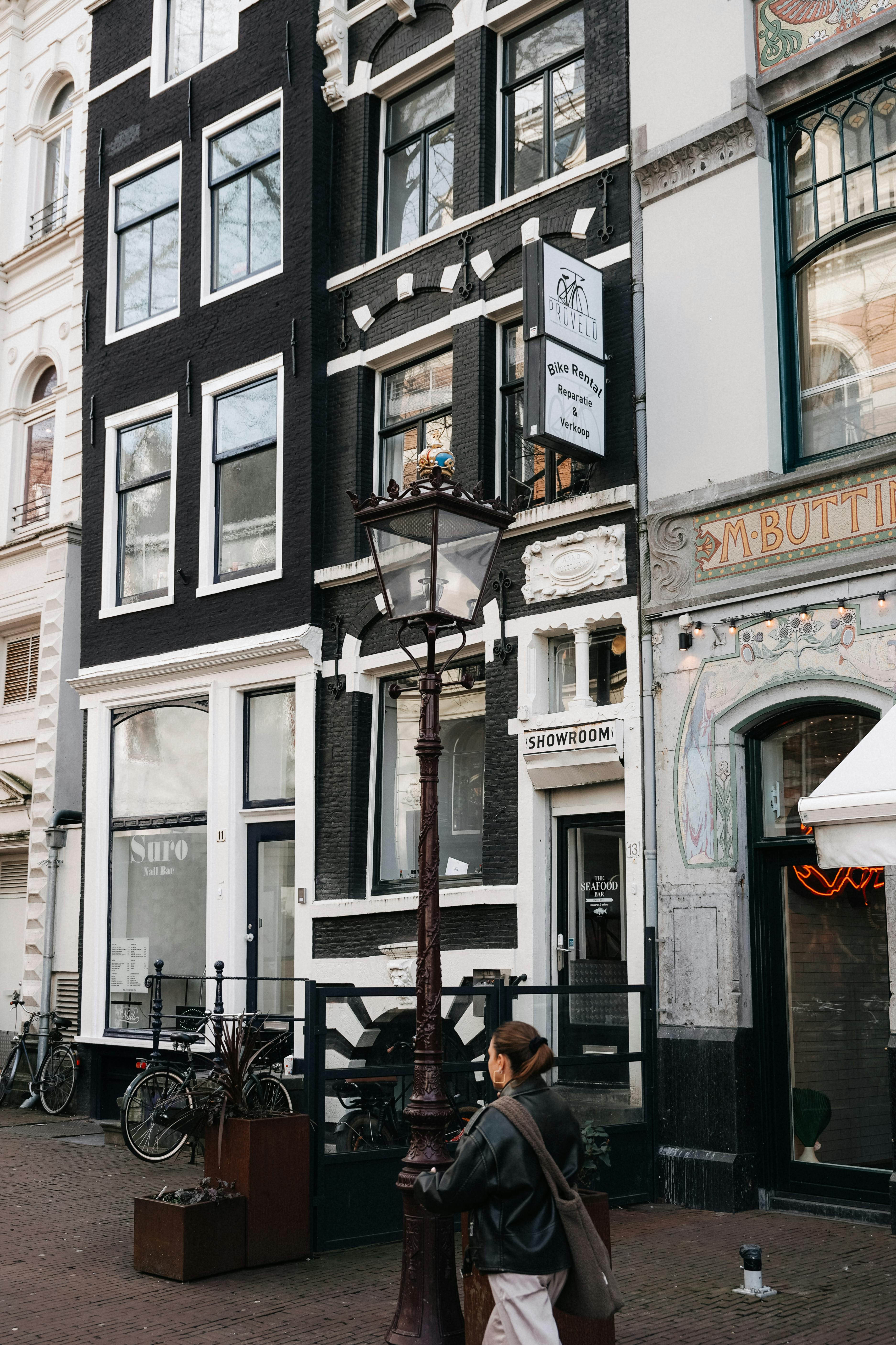 Authentic street view of Amsterdam with iconic architecture and a passerby.