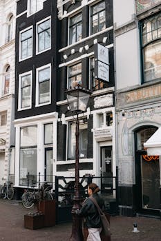 Authentic street view of Amsterdam with iconic architecture and a passerby.