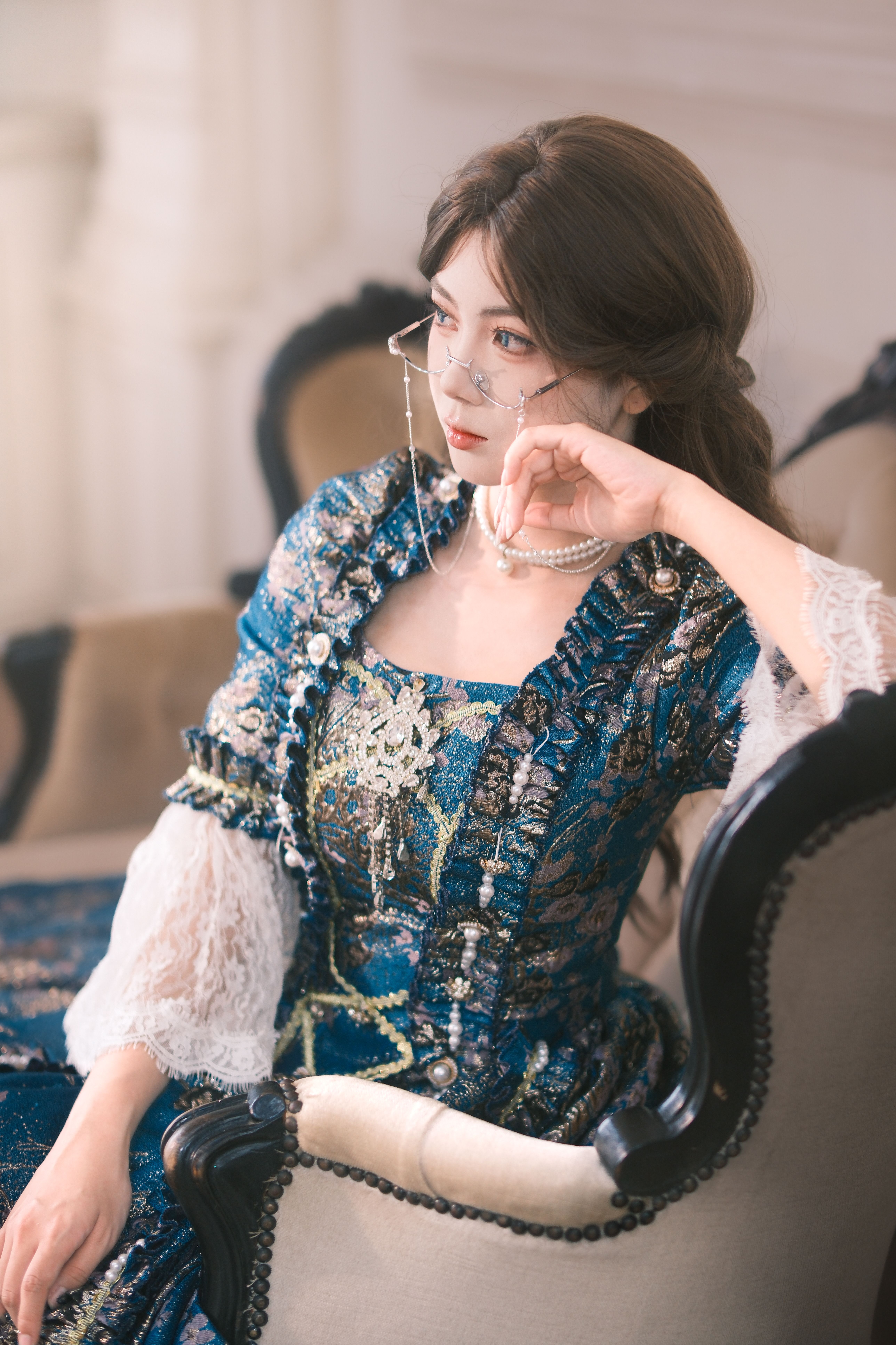 Elegant Woman in Vintage Blue Dress Sitting Indoors · Free Stock Photo