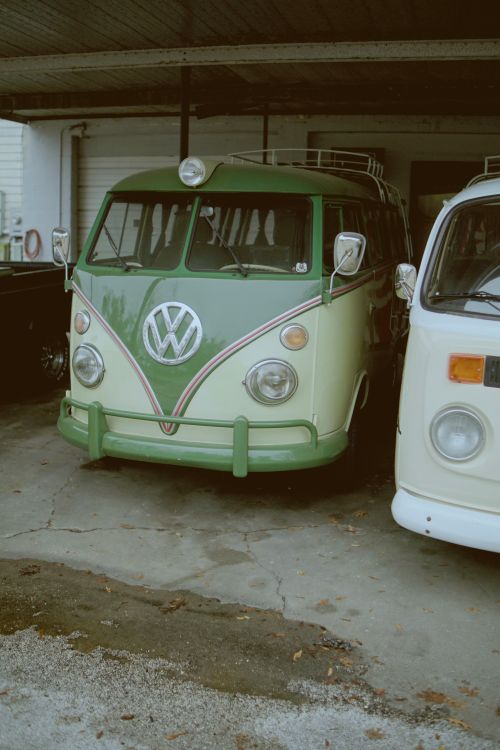 Free Classic green Volkswagen van parked under a carport, exuding retro charm. Stock Photo