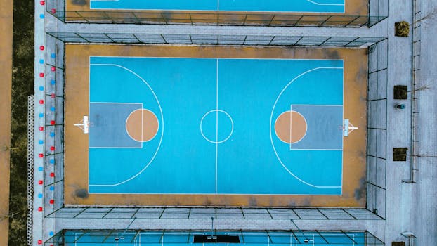 Top-down view of a vibrant blue basketball court with clear layout and markings.