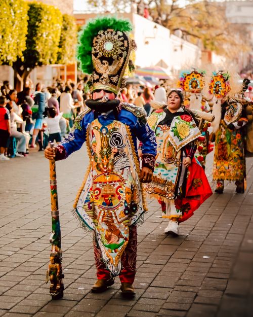 Free Colorful parade featuring traditional costumes, dancers, and cultural celebration in a lively street setting. Stock Photo