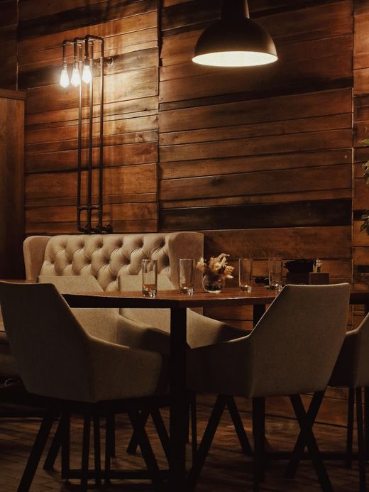 Warm timber-panelled dining room with banquette seating — photo by Dmitry Alexandrovich on Pexels
