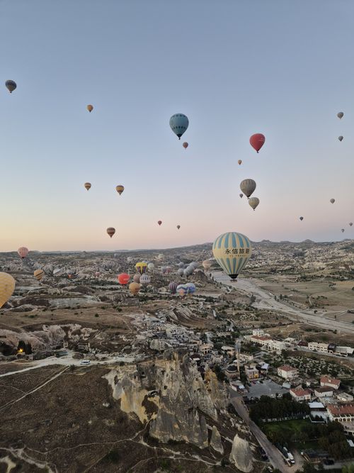 Free Scenic view of hot air balloons soaring over Cappadocia's unique landscape at sunrise. Stock Photo