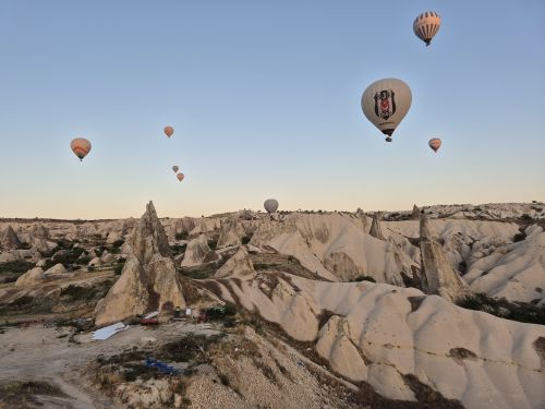 Free Aerial view of hot air balloons floating above the rocky formations of Cappadocia at sunrise. Stock Photo