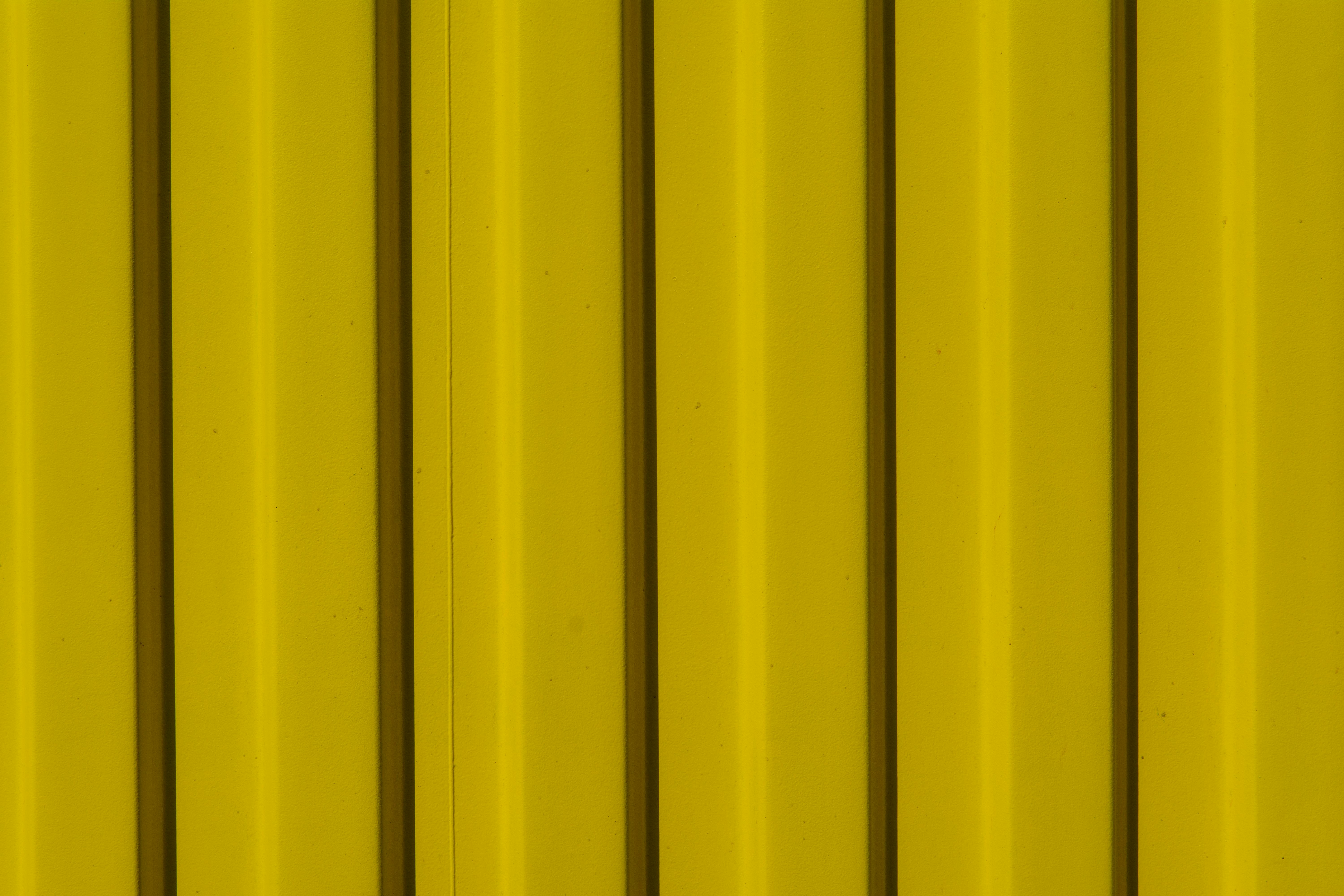 Free Close-up of a vibrant yellow corrugated metal surface for industrial backgrounds. Stock Photo