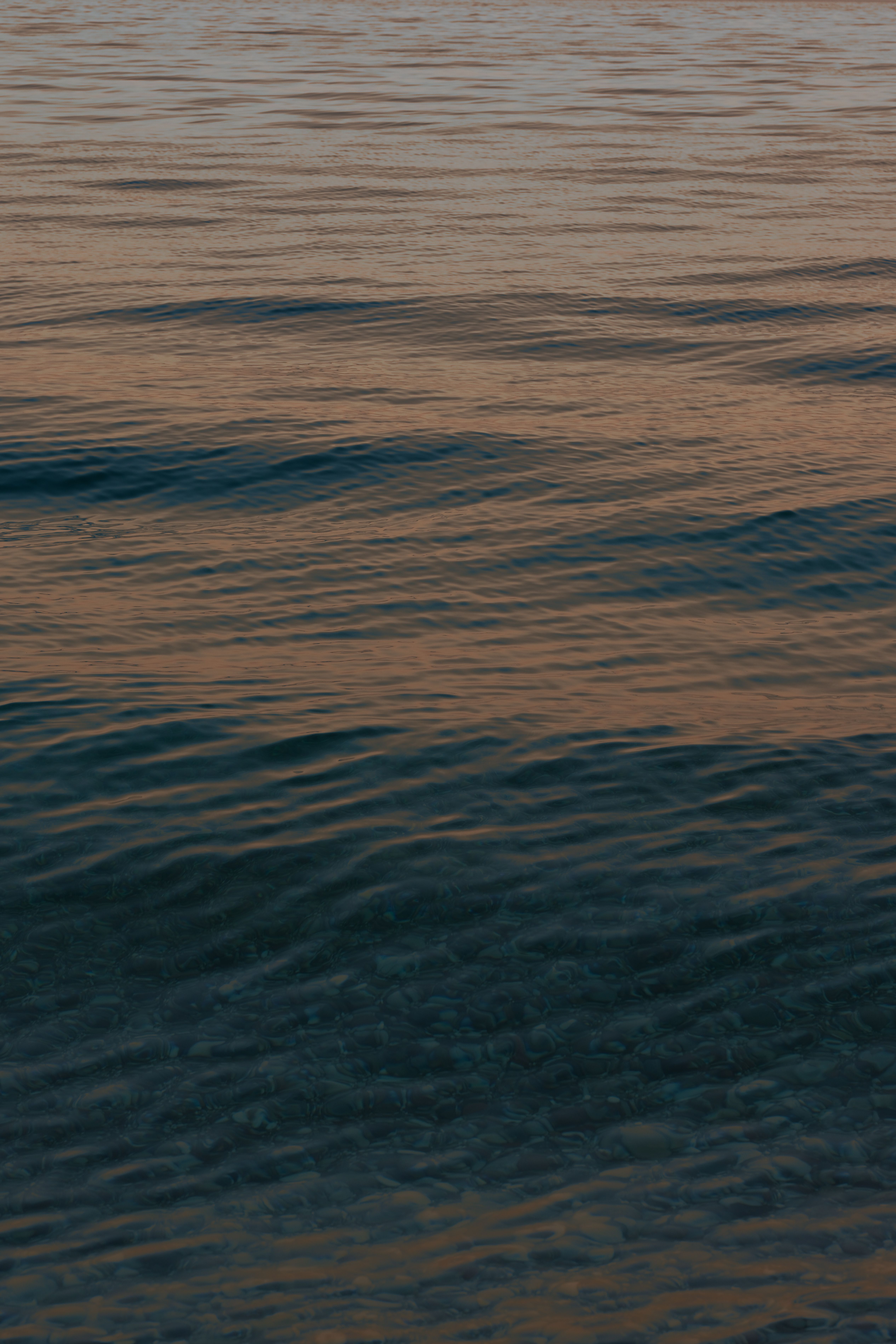 Tranquil ocean waves reflecting the warm hues of twilight.