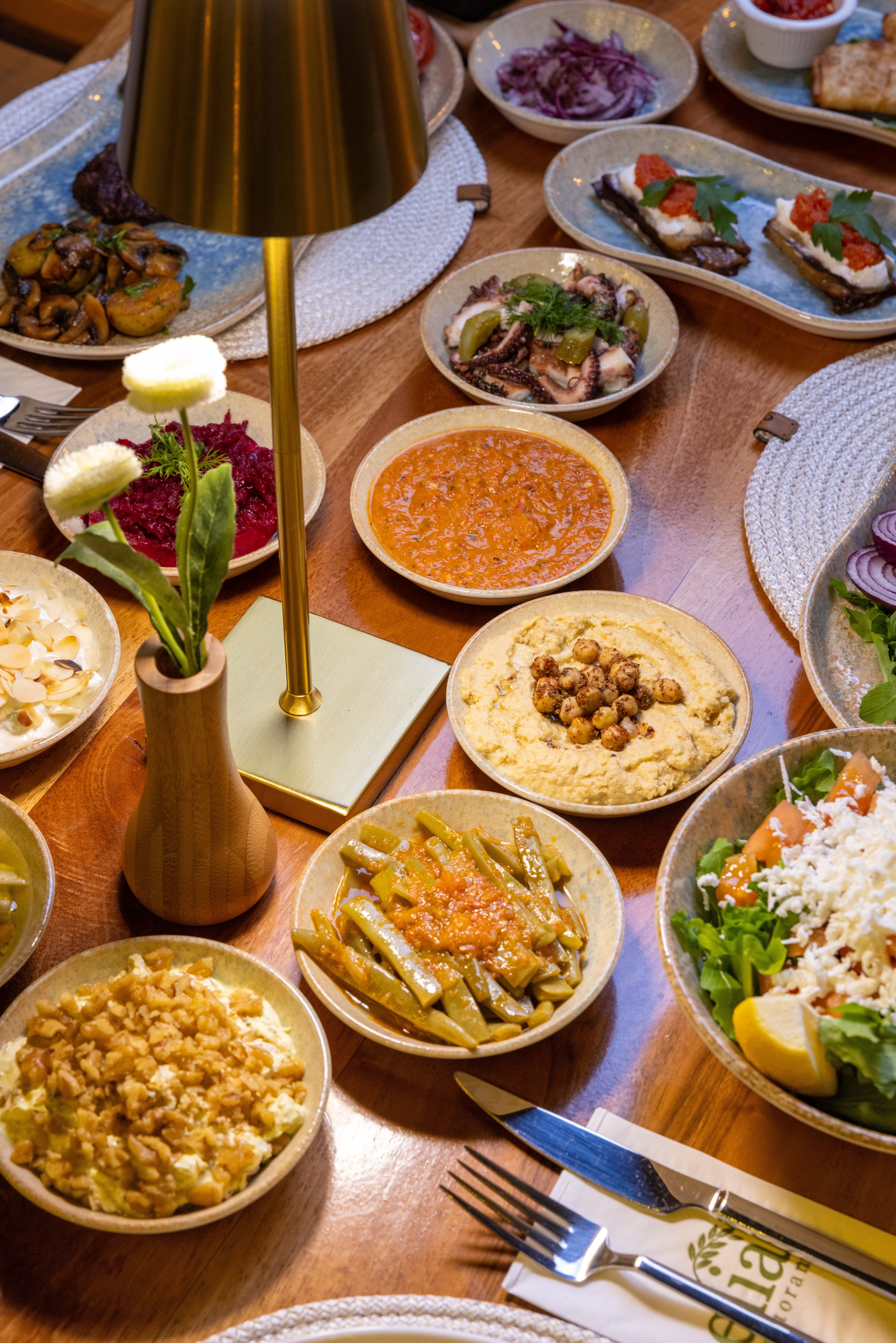 An array of delicious Mediterranean dishes arranged on a wooden table, perfect for sharing.