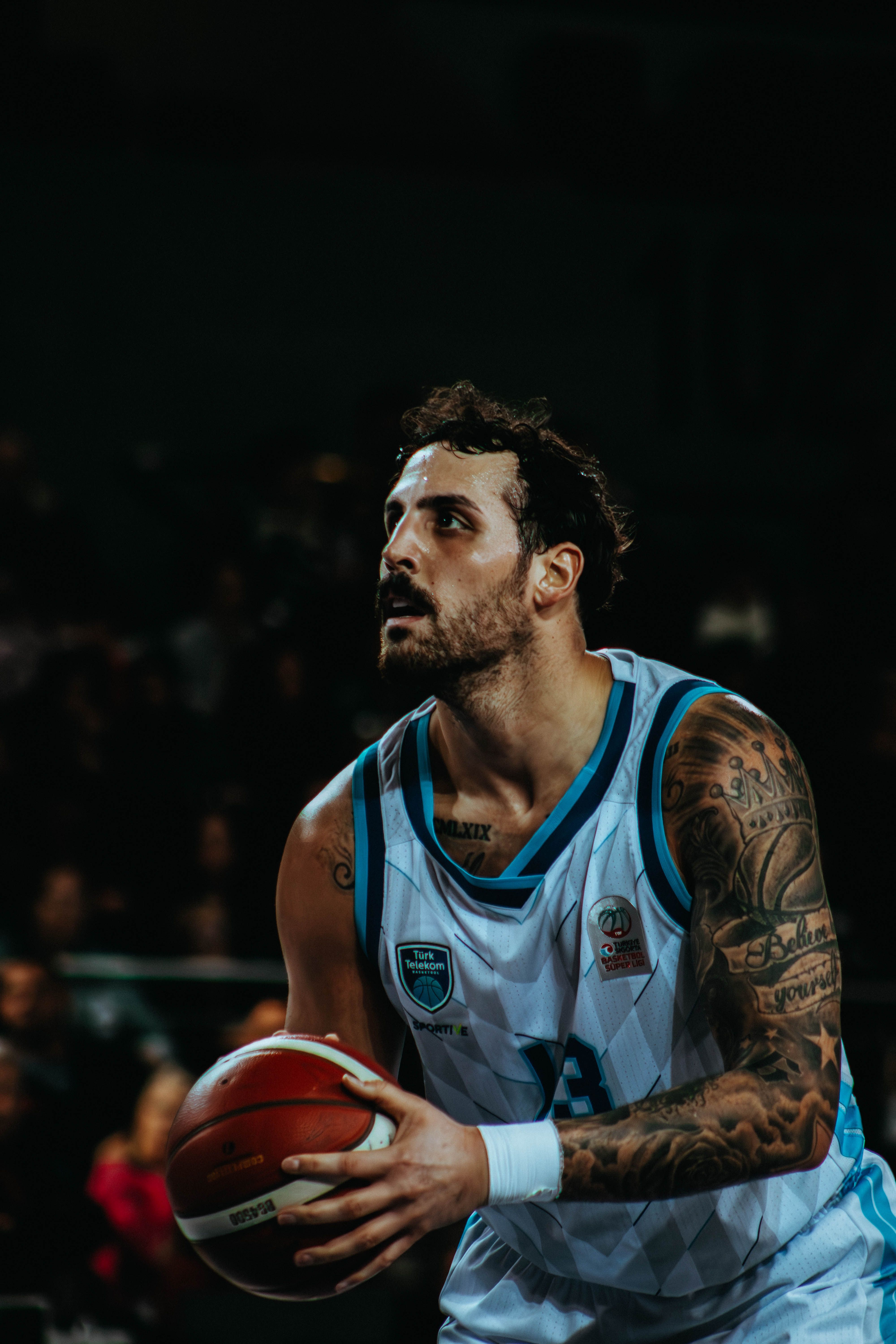 Male basketball player in action, preparing to shoot during a game.