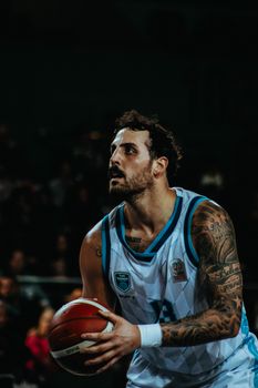 Male basketball player in action, preparing to shoot during a game.