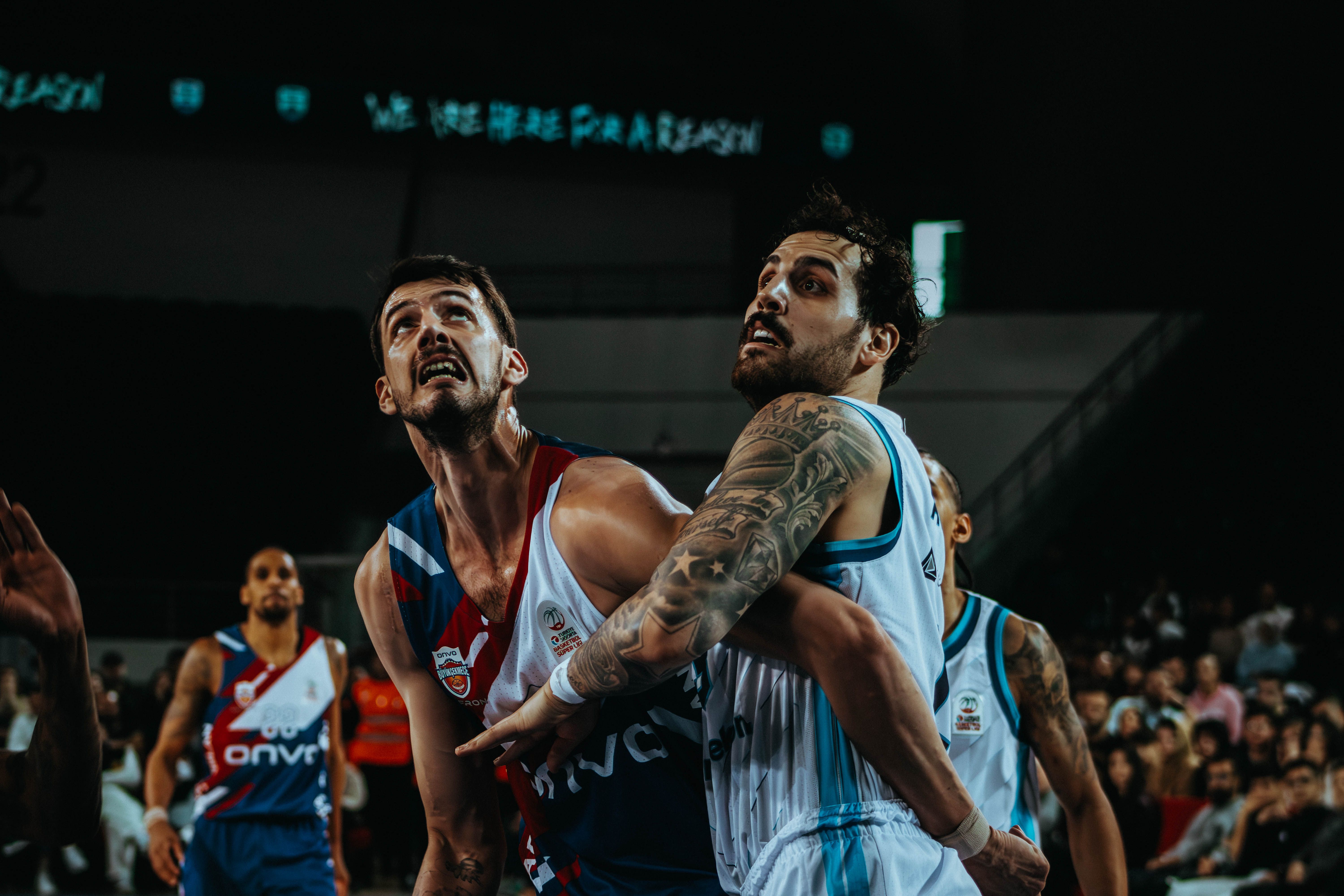 NCAA Basketball photo featuring Two male basketball players in action during an intense game. Competitive sports photography.