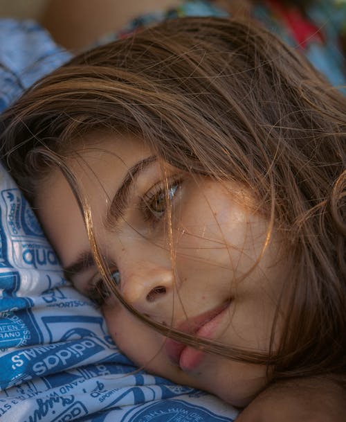 Free Serene young female with messy hair dreaming while lying on person and looking away Stock Photo