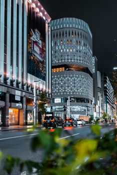 Vibrant night scene of Ginza, Tokyo filled with lights and modern architecture.