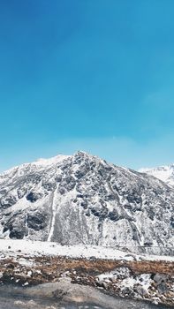 Majestic snow-covered mountain peak under a vibrant blue sky, perfect for winter imagery.
