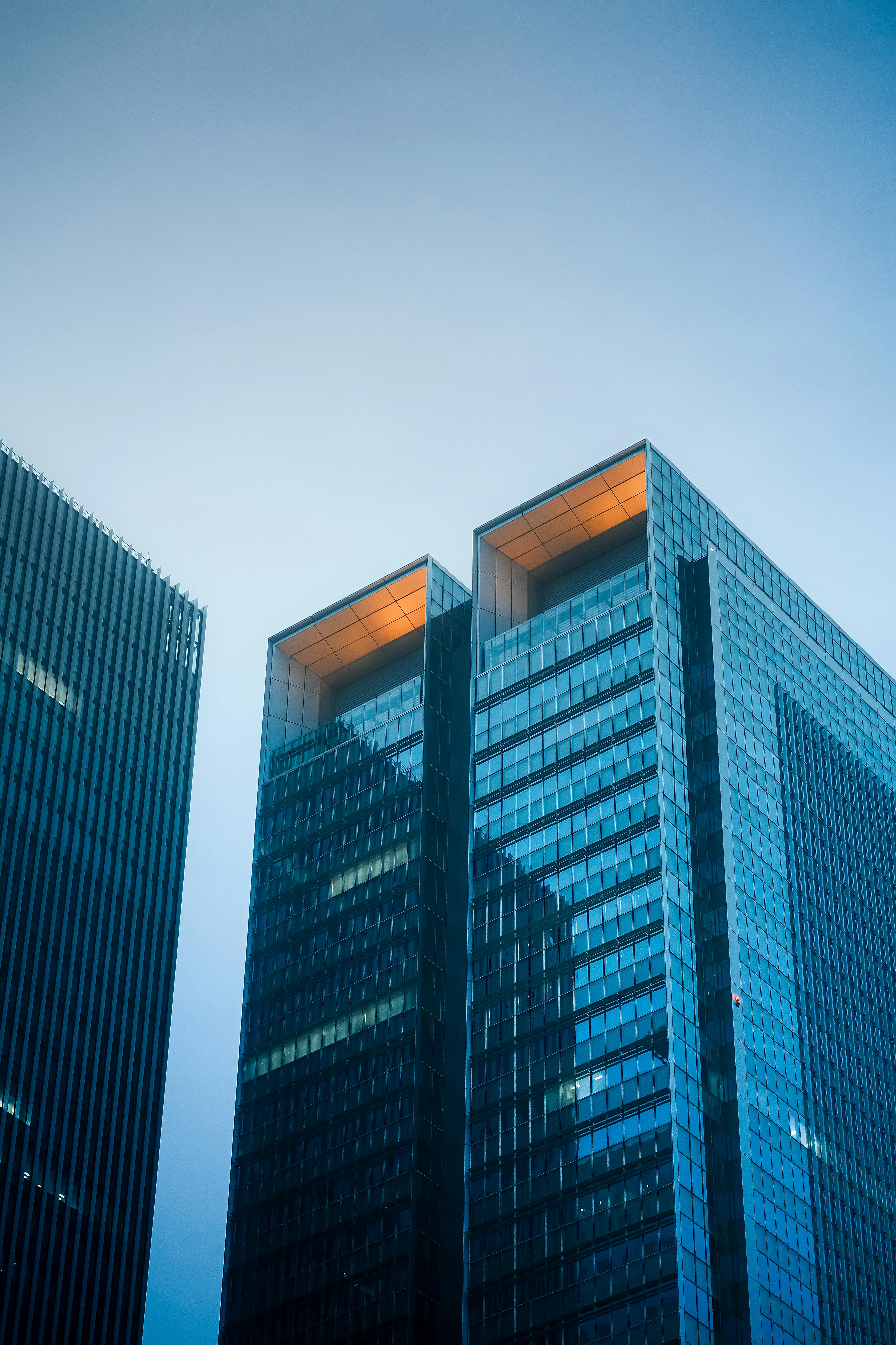High-rise glass buildings with a modern architectural design against a clear blue sky.