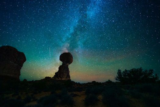 Iconic Balanced Rock under a mesmerizing Milky Way sky in Utah's Arches National Park.