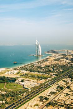 A stunning aerial shot of the iconic Burj Al Arab on the Dubai coastline during the day.