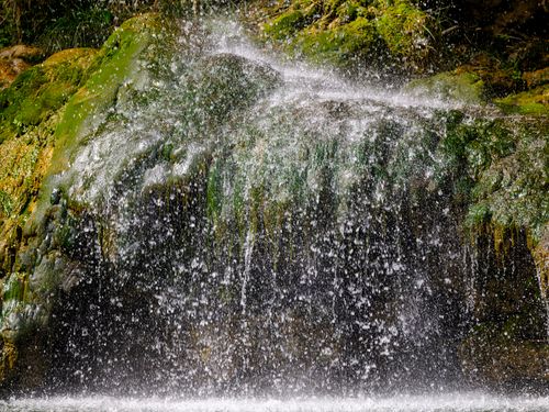 Free Vibrant waterfall cascading over moss-covered rocks, capturing a fresh, natural outdoor scene. Stock Photo