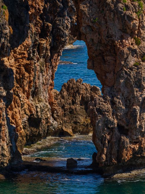 Free Explore the stunning natural rock arch along the coastline of Antalya, offering breathtaking views of the azure sea. Stock Photo