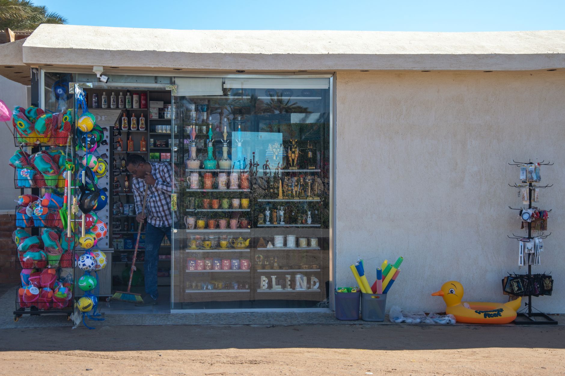 funday inflatables and games egypt — A small souvenir shop with beach toys and inflatables on display outside.