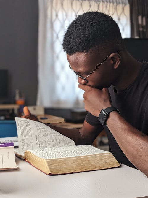 Man Wearing Black Crew-neck Shirt Reading Book