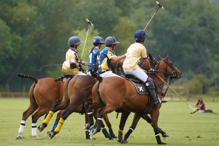 Jugadores de polo al galope con los tacos en alto