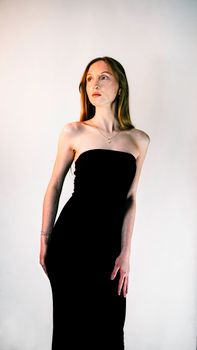 Stunning studio portrait of a woman in an elegant black dress, exuding sophistication.