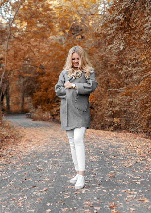 Gratis Mujer Vestida Con Abrigo Gris Y Polainas Blancas De Pie En Medio De La Carretera Foto de stock