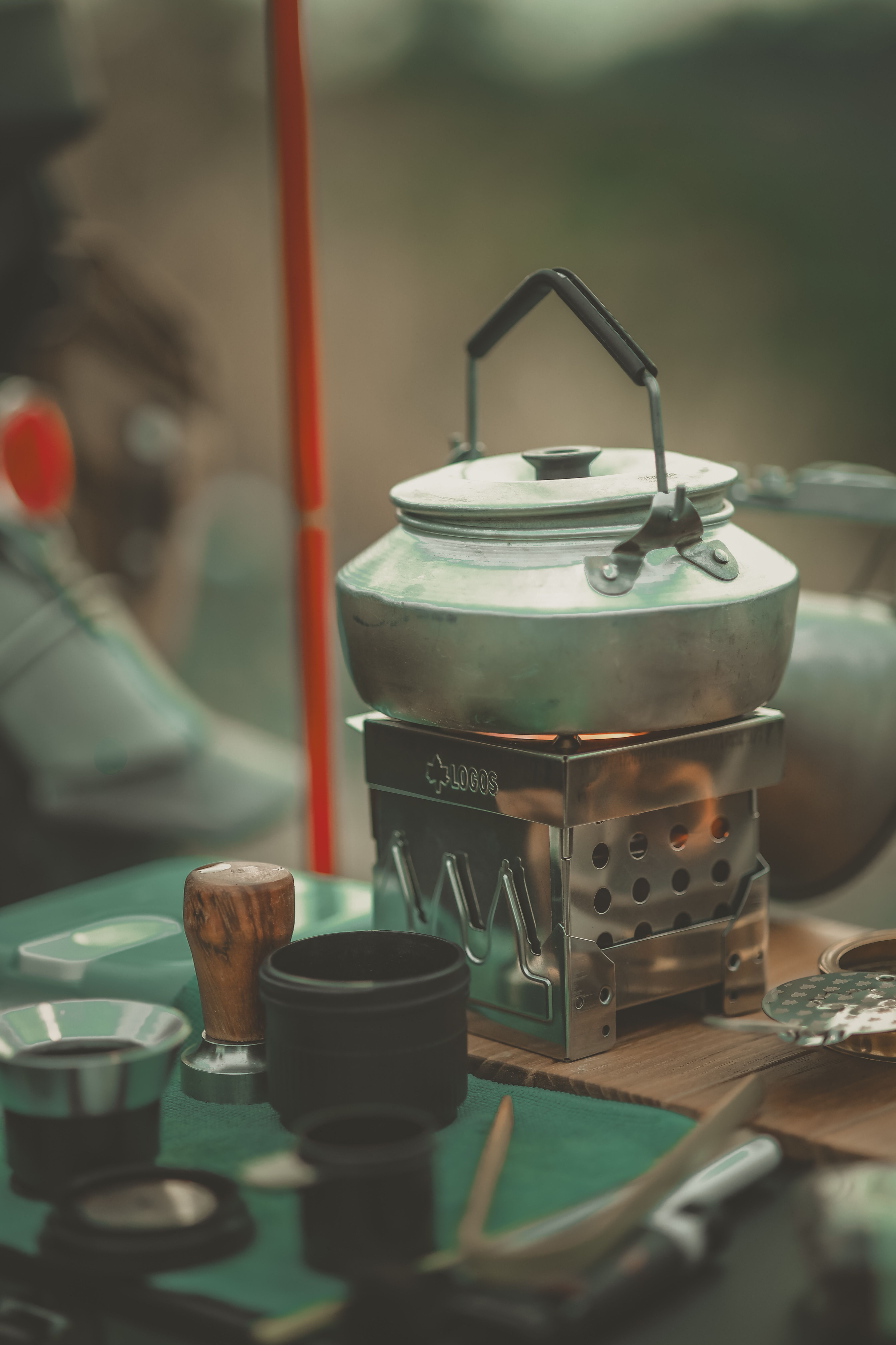 Coleman Cascade 3-in-1 camp stove set up on a picnic table with interchangeable cooktops