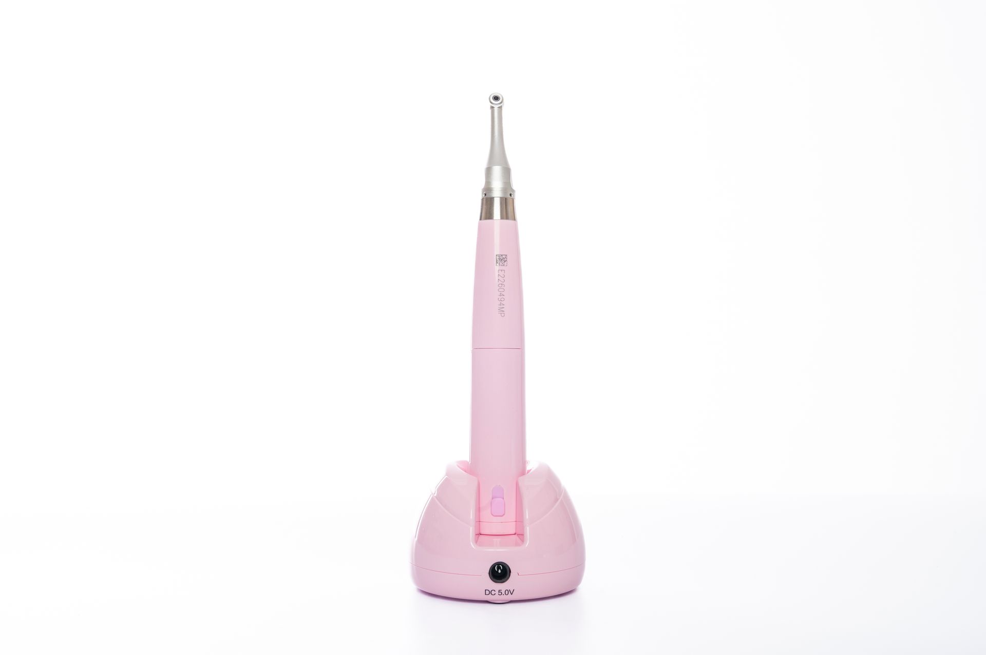 Dental handpiece device in pastel pink isolated on white for clinical use.