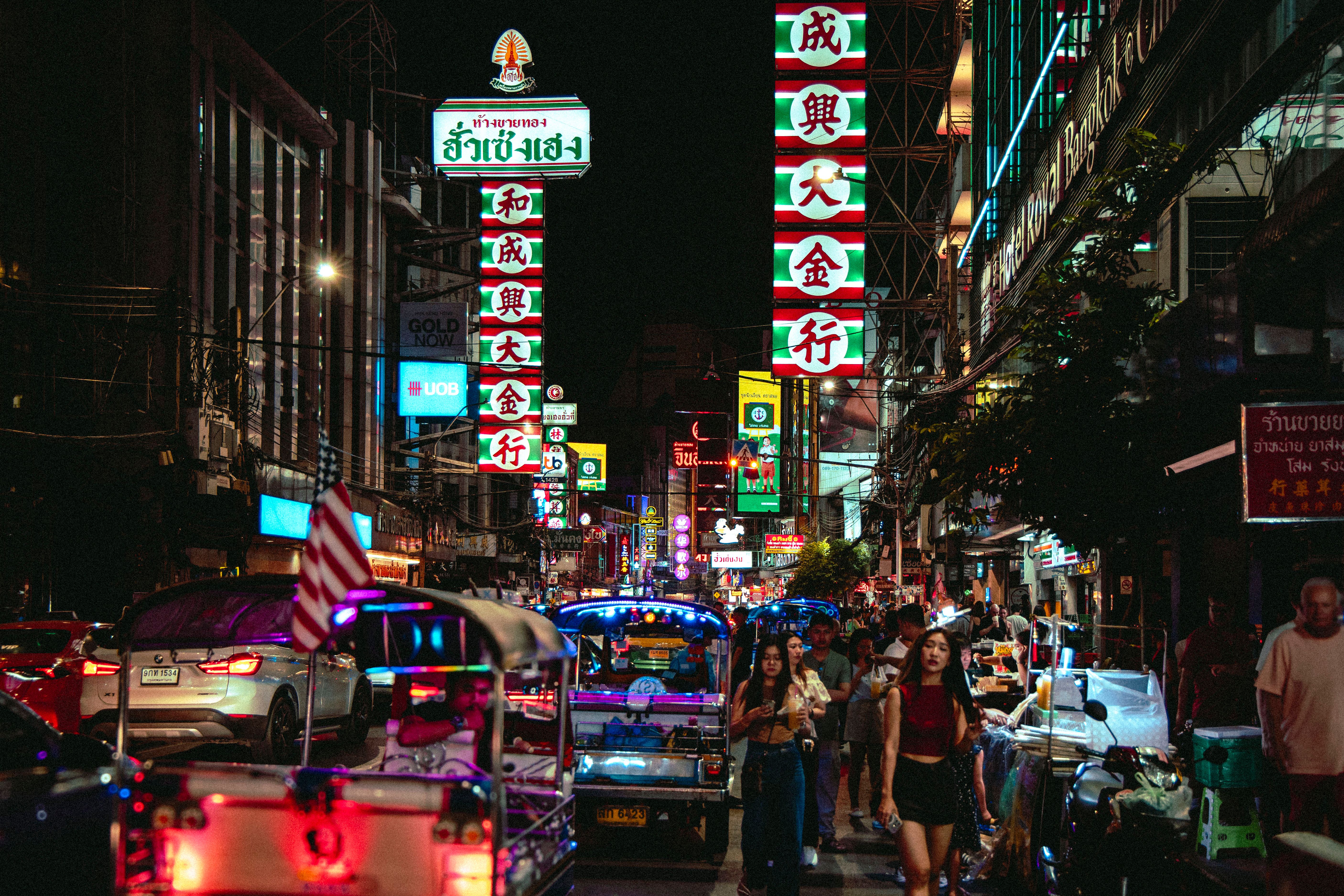 Gratuit Scène nocturne animée dans le quartier chinois de Bangkok avec des tuk-tuks et des néons. Photos