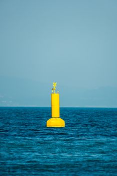 A vibrant yellow buoy floating in the tranquil blue waters of Yalova, Türkiye.