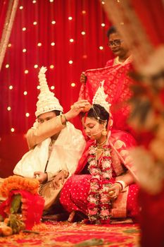A vibrant and traditional Bengali wedding ceremony in West Bengal, India.