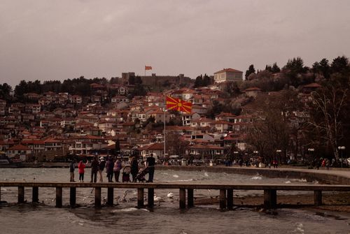 Free A serene landscape of Ohrid featuring the North Macedonian flag and historical architecture. Stock Photo