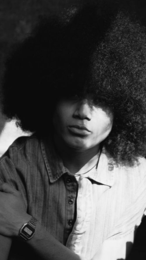 Free Black and white portrait of a man with an afro hairstyle wearing a denim shirt. Stock Photo
