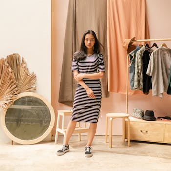 一位时尚女士身着条纹连衣裙，在精品店里优雅地摆出姿势