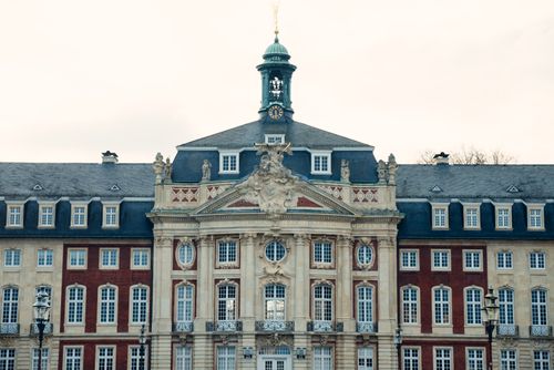Free A stunning example of Baroque architecture, featuring ornate details and a central clock tower. Stock Photo