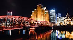 美丽的城市夜景中，一座发光的桥梁与倒映在水面的天际线交相辉映