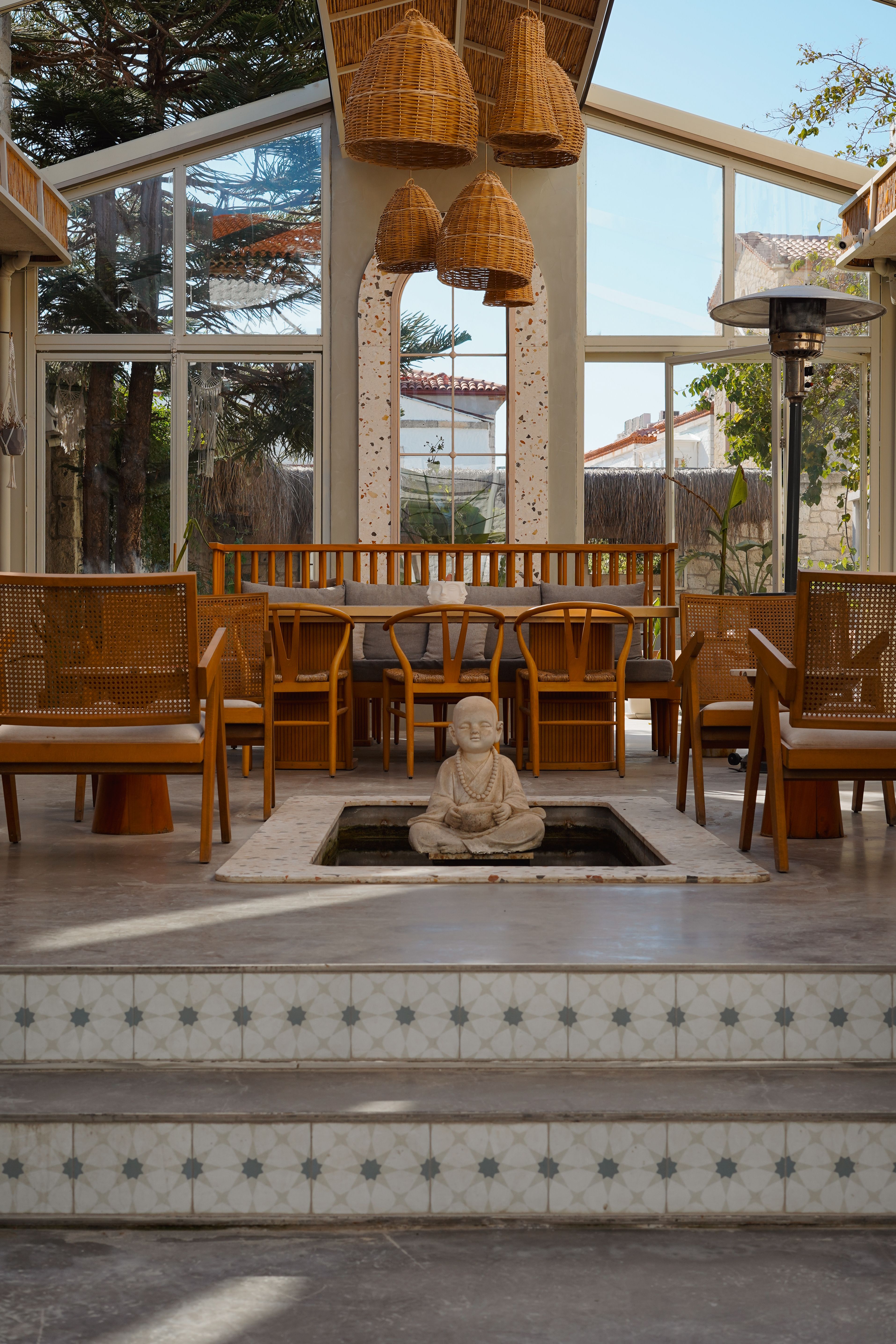 Peaceful dining space with wooden furniture and a Buddha statue centerpiece.