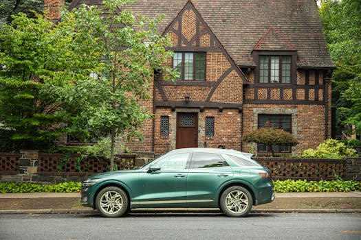 A luxury SUV parked in front of a traditional Tudor-style house in New York, showcasing classic architecture.