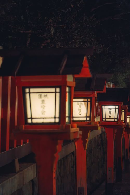 Free A row of illuminated Japanese lanterns creating a serene nighttime atmosphere. Stock Photo