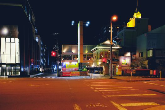 Illuminated city street scene at night showcasing vibrant lights and architecture.