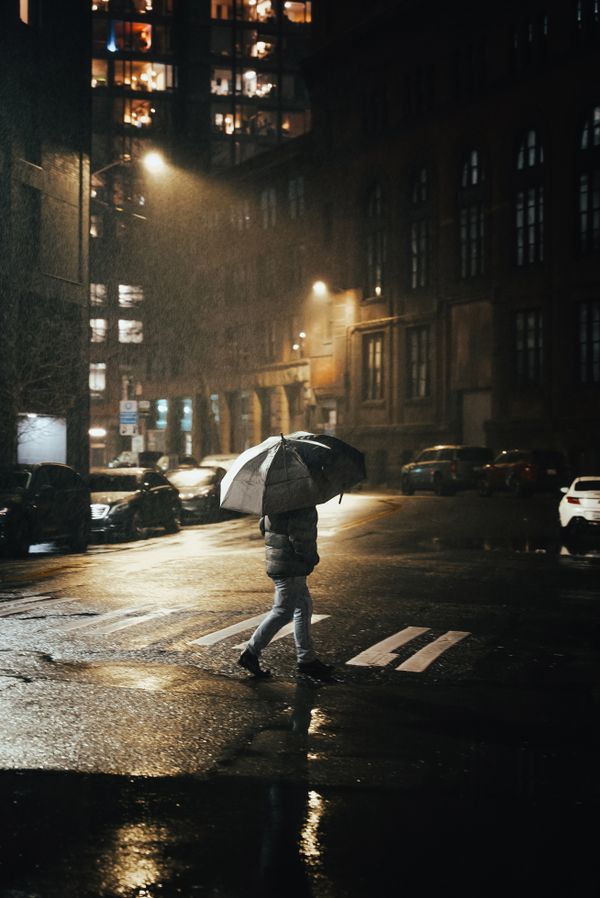 Person with an umbrella on a rainy Seattle street at night, typical weather when moving in the rain