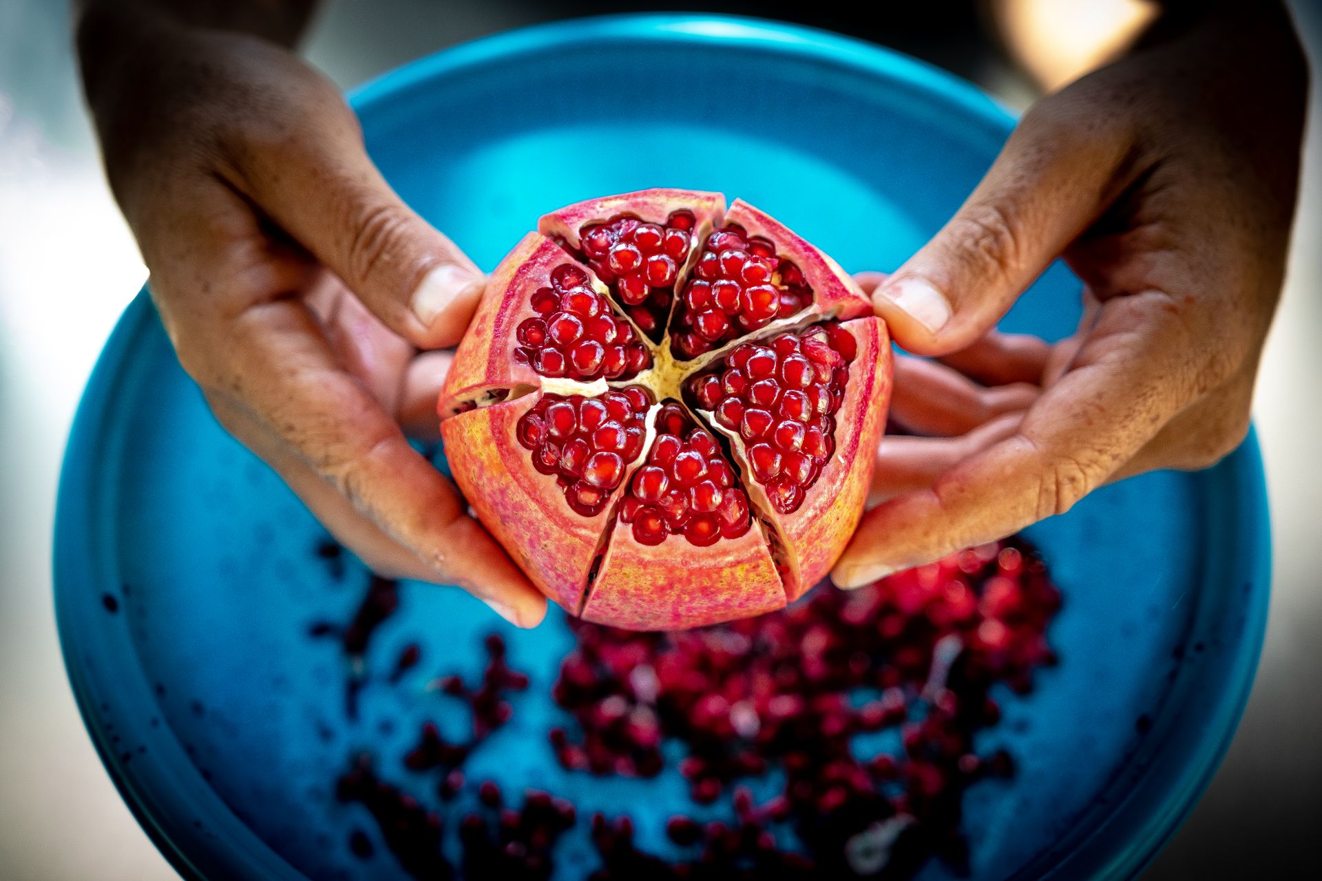 Close-up Photo of Person Holding Pomegranate Fruit