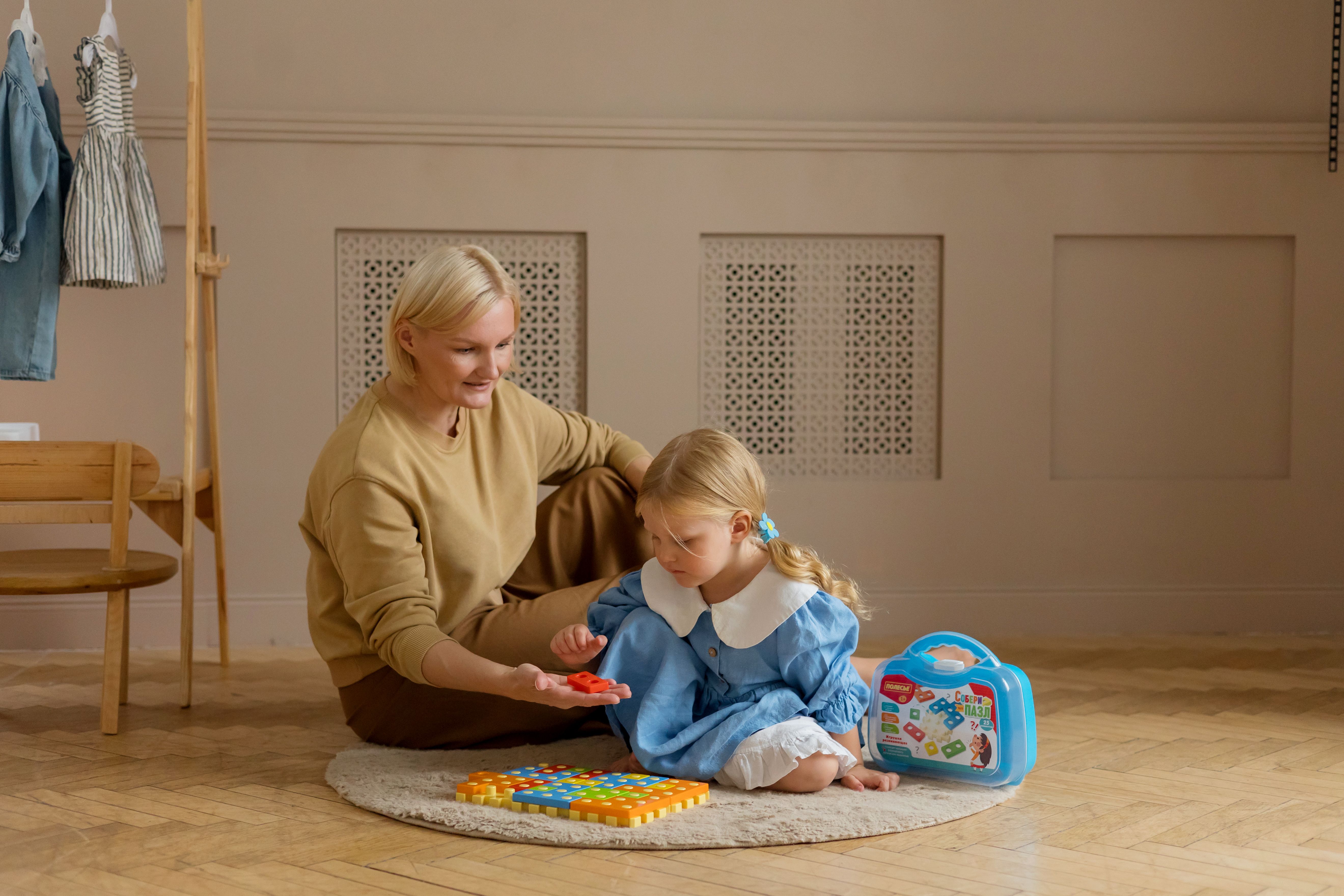 Mom and daughter enjoying quality time with educational toys indoors, fostering a learning environment.