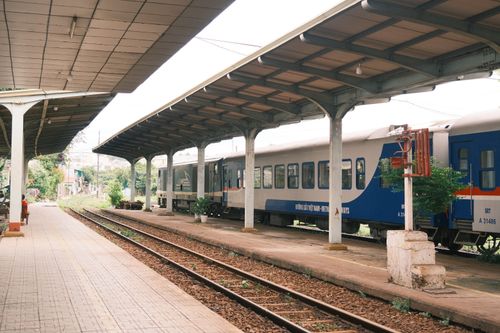 Free Empty railway station platform in Vietnam with a train parked under a covered roof. Stock Photo
